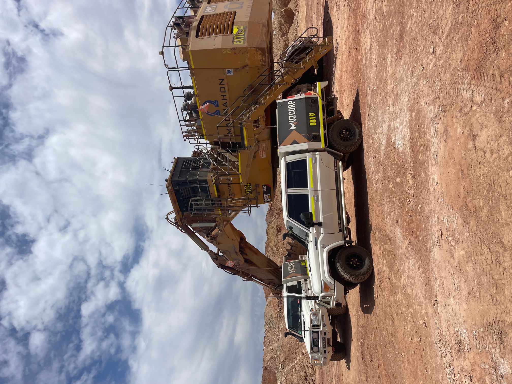 Muzcorp truck next to CAT excavator